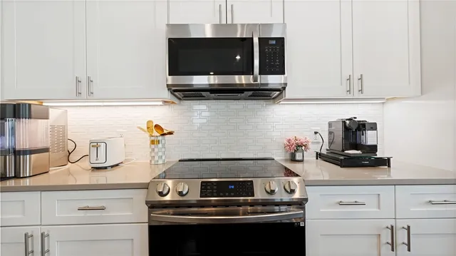 a kitchen with stainless steel appliances granite countertop a stove and a microwave
