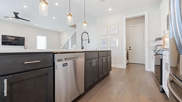 a kitchen with a sink a refrigerator and wooden floor