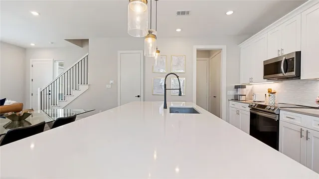 a kitchen with sink a stove and cabinets