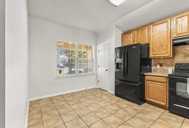 a kitchen with stainless steel appliances a refrigerator and a stove top oven