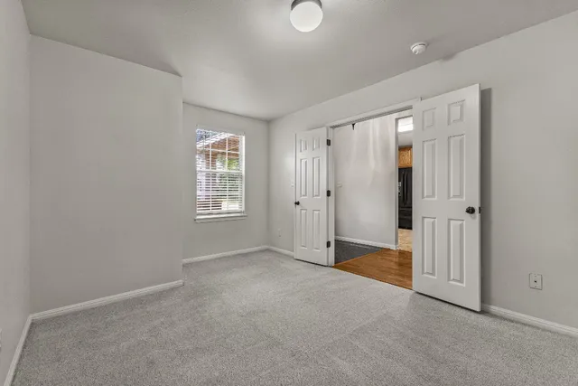 an empty room with windows and closet