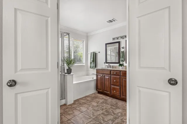 a bathroom with a tub a sink and mirror