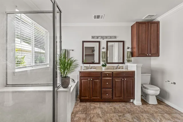 a spacious bathroom with a granite countertop sink a toilet and a mirror