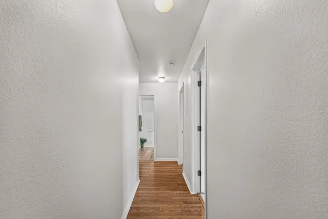 a view of a hallway with wooden floor
