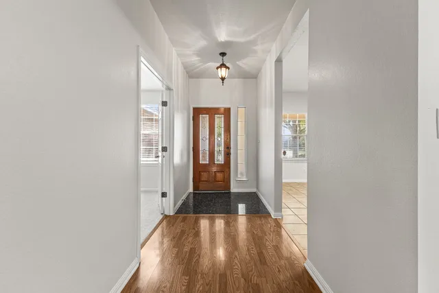wooden floor in an empty room with a kitchen