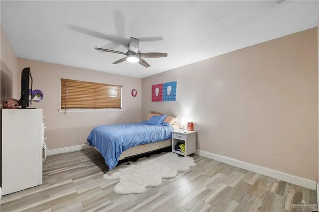 a bedroom with a bed chandelier and a window