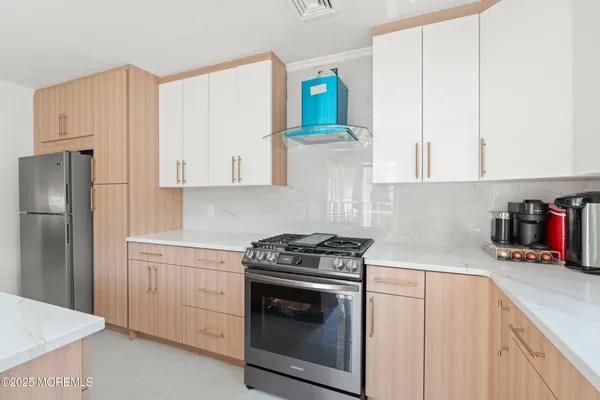 a kitchen with stainless steel appliances white cabinets and a stove top oven