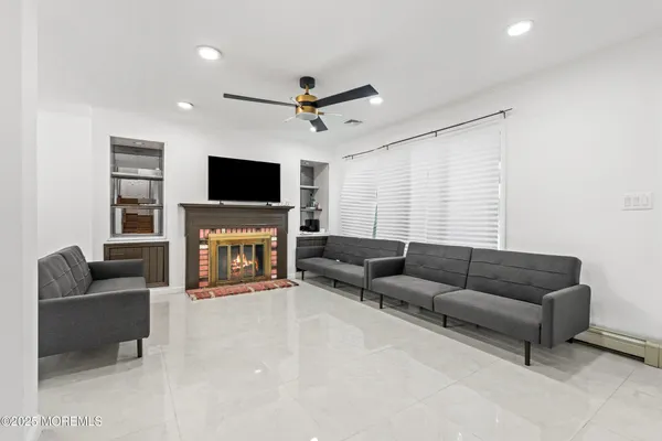 a living room with furniture a fireplace and a flat screen tv