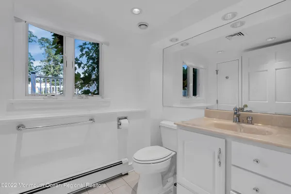 a bathroom with a sink toilet and window