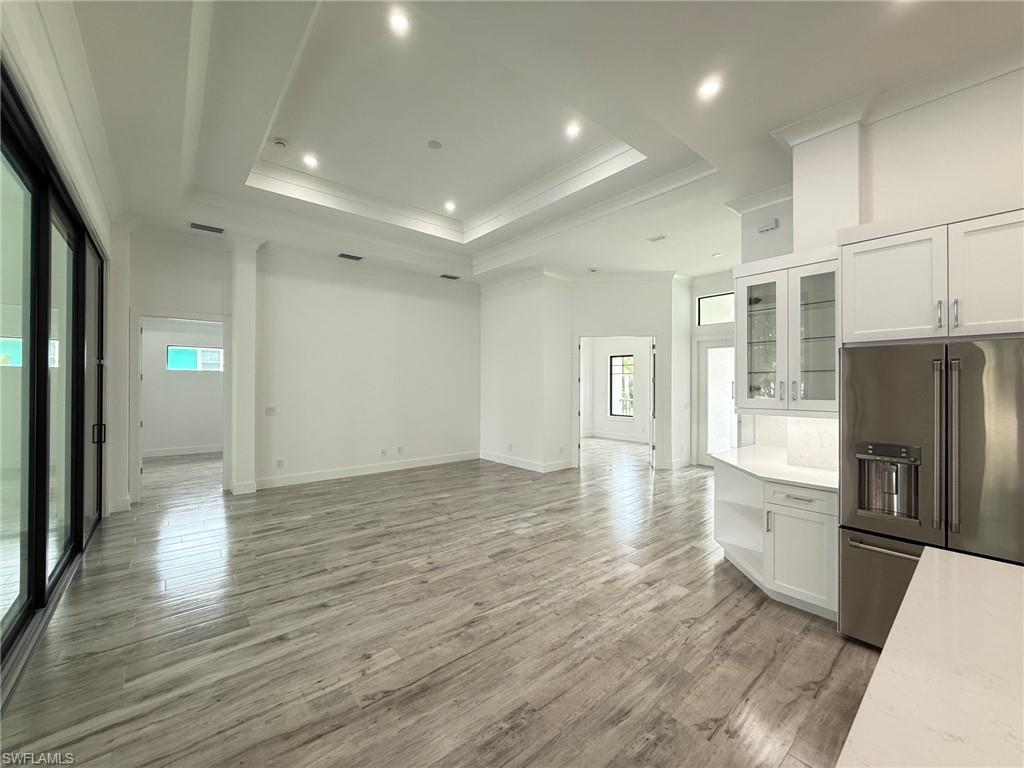 82 Tahiti Road Marco Island, FL 34145 - Photo 12 of 27 an empty room with wooden floor and windows