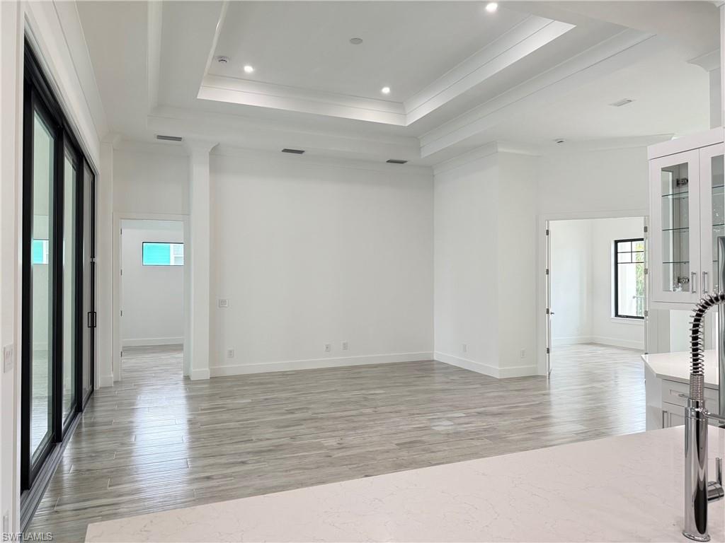 82 Tahiti Road Marco Island, FL 34145 - Photo 13 of 27 wooden floor in an empty room with a window