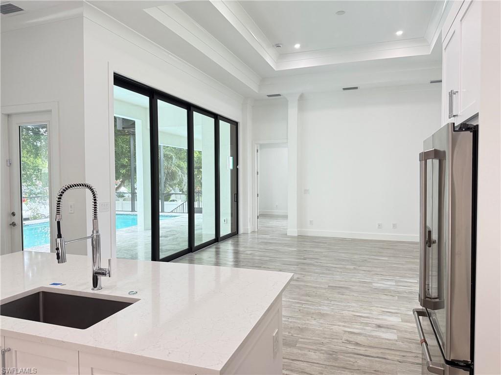 82 Tahiti Road Marco Island, FL 34145 - Photo 14 of 27 a kitchen with kitchen island a sink appliances and a counter top space