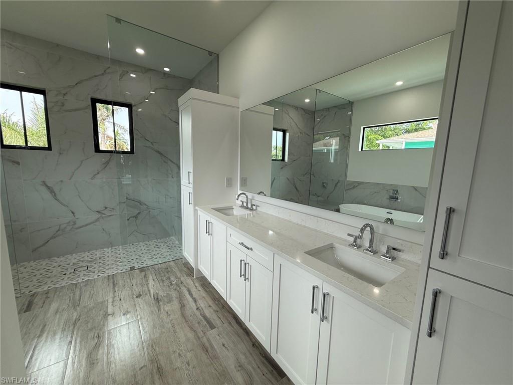 82 Tahiti Road Marco Island, FL 34145 - Photo 19 of 27 a spacious bathroom with double vanity and mirrors