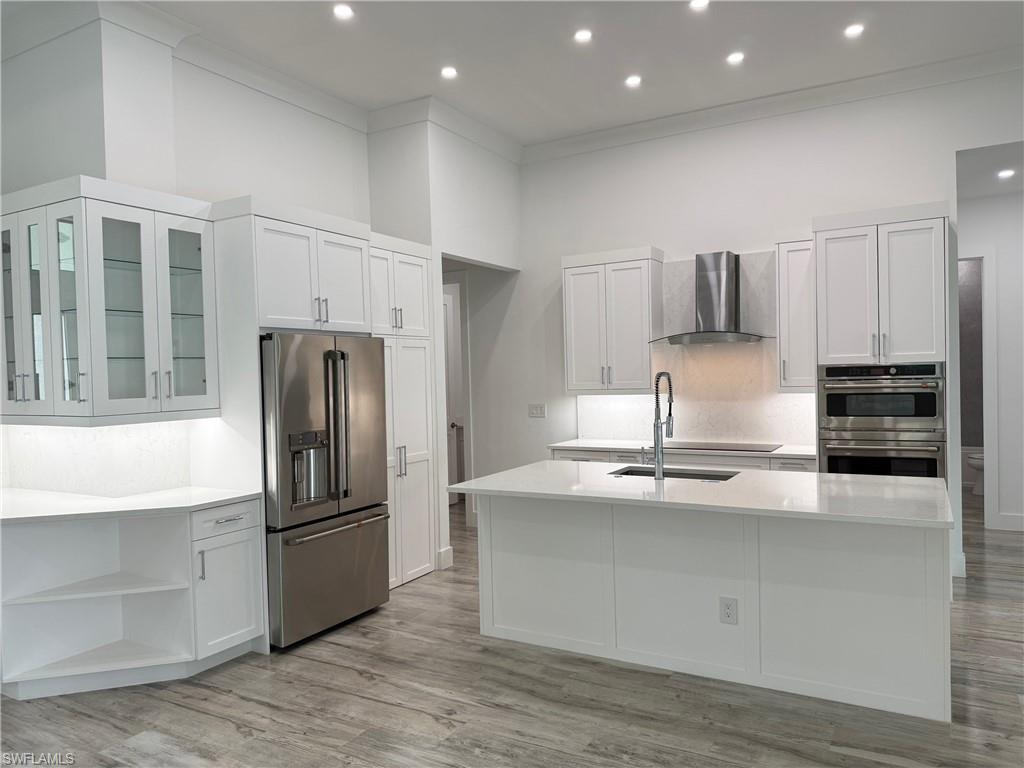 82 Tahiti Road Marco Island, FL 34145 - Photo 10 of 27 a kitchen with kitchen island a counter top a refrigerator and a sink