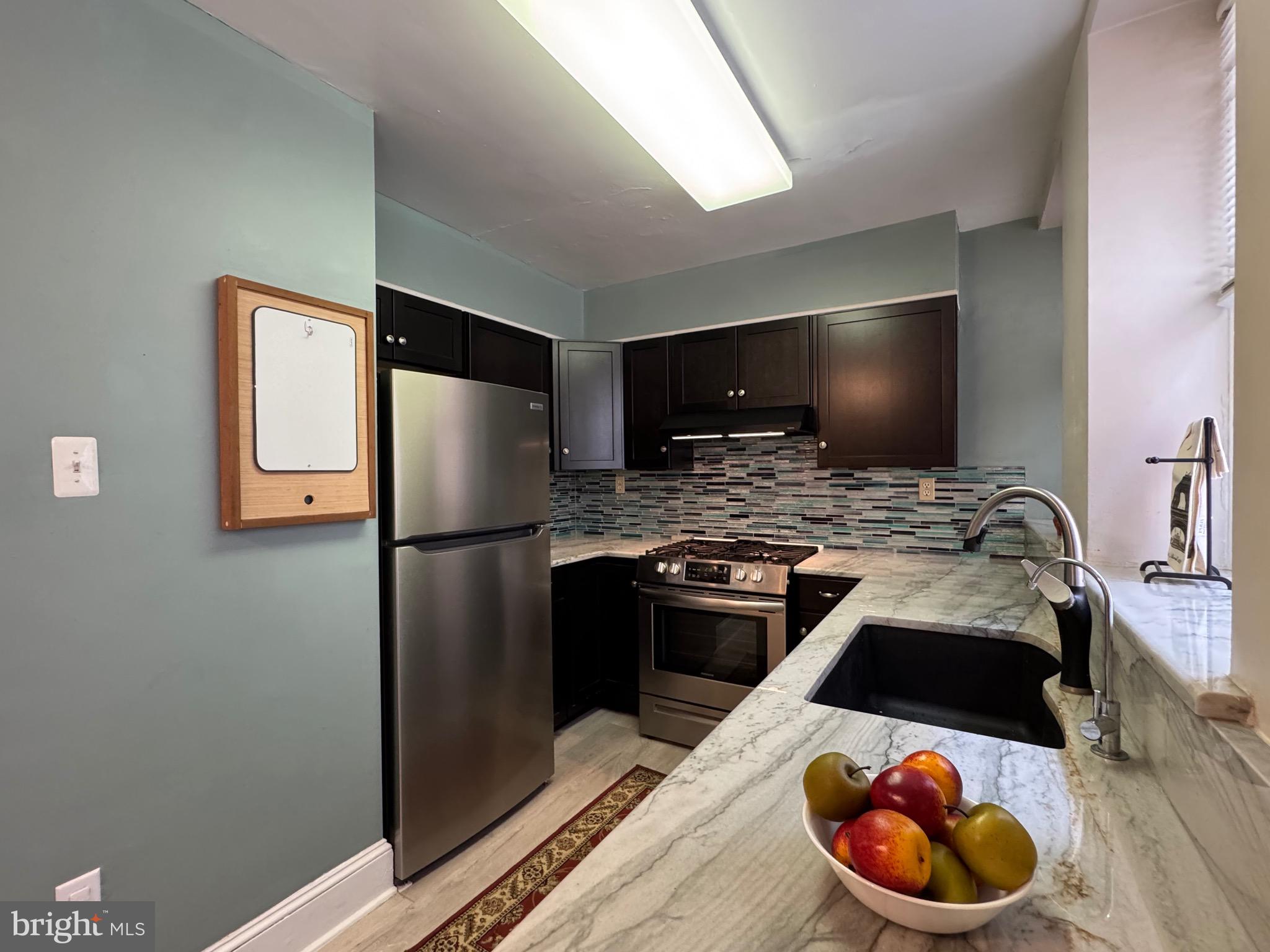4643 Pine Street, Unit C411 Philadelphia, PA 19143 - Photo 27 of 60 a kitchen with a refrigerator and a stove top oven