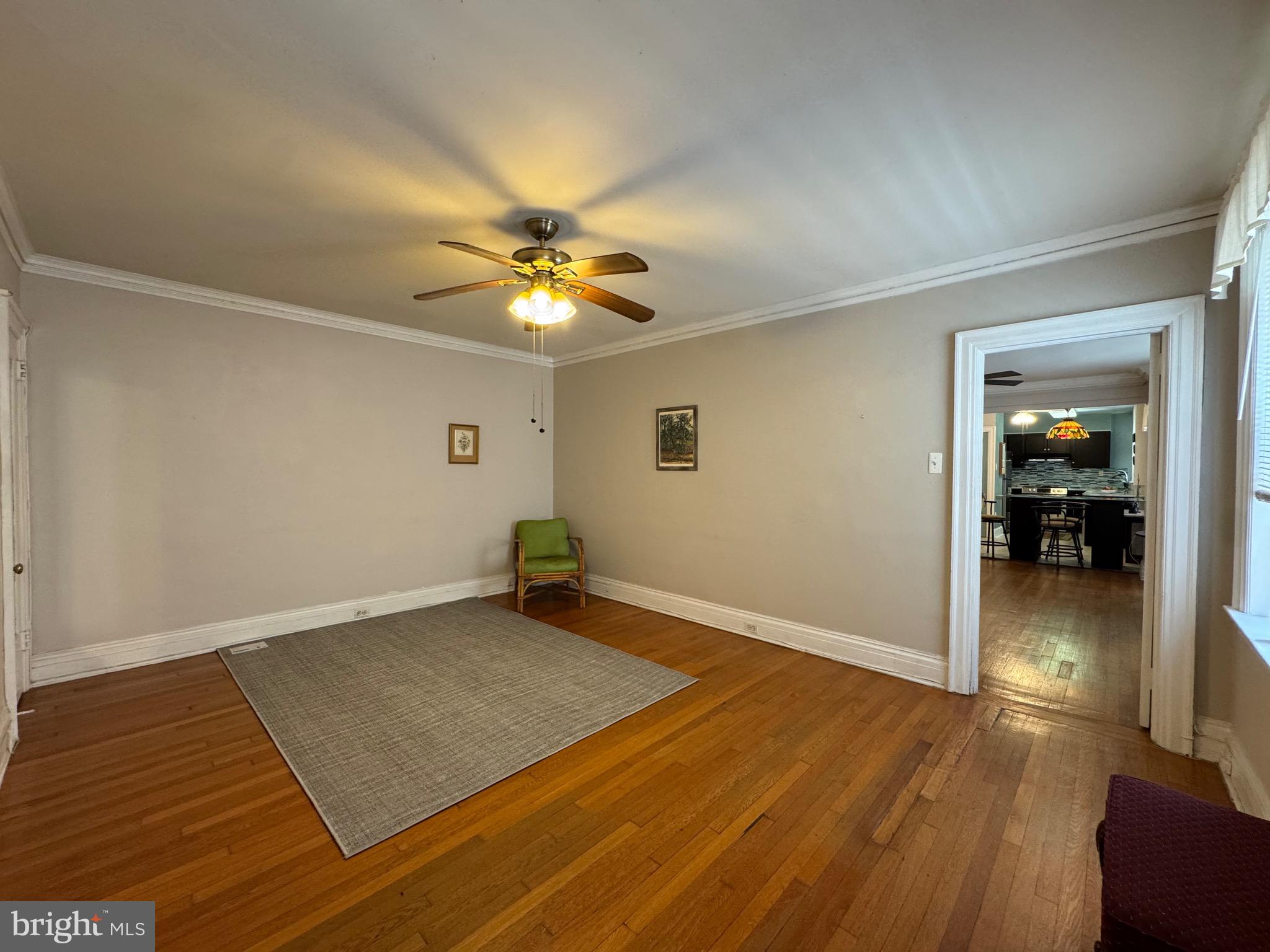 4643 Pine Street, Unit C411 Philadelphia, PA 19143 - Photo 29 of 60 an empty room with wooden floor and a ceiling fan