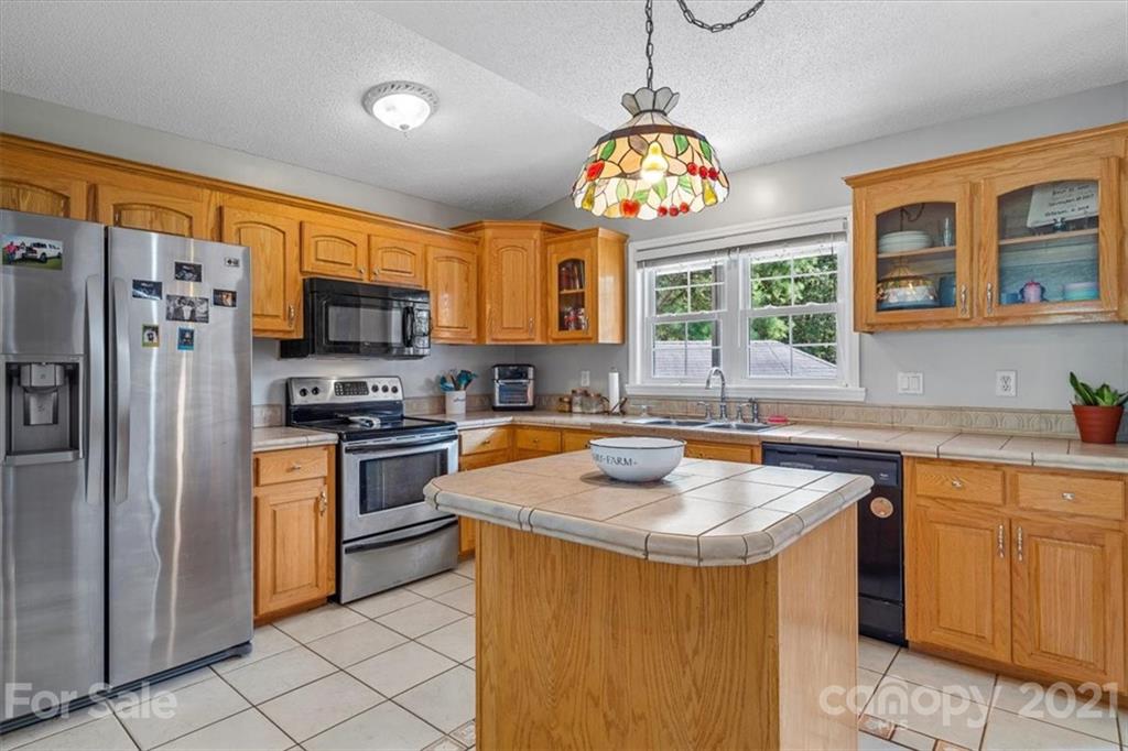 308 Kiser Road Bessemer City, NC 28016 - Photo 7 of 32 a kitchen with stainless steel appliances granite countertop a sink a stove a refrigerator cabinets and a dining table