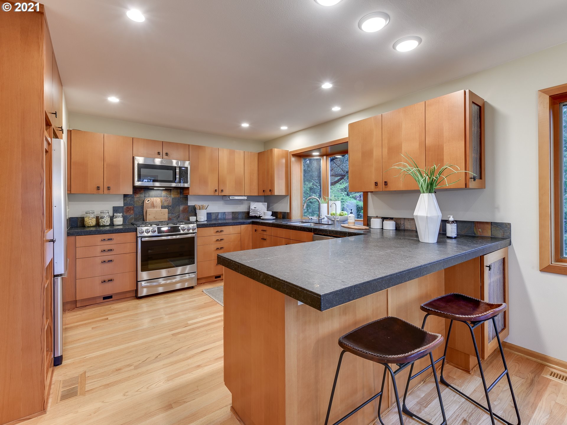 3630 Southwest Patton Road Portland, OR 97221 - Photo 9 of 29 a kitchen with stainless steel appliances a table chairs sink and cabinets