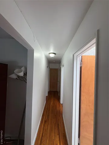 a view of a hallway with wooden floor and a glass door