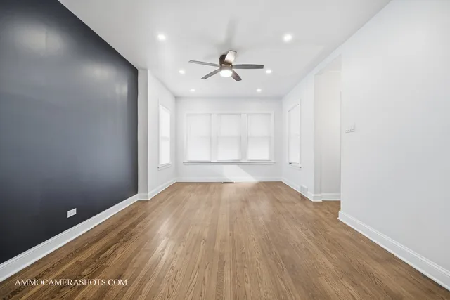 a view of a big room with wooden floor and a ceiling fan