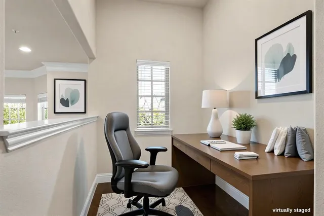 a view of a workspace with furniture and a window