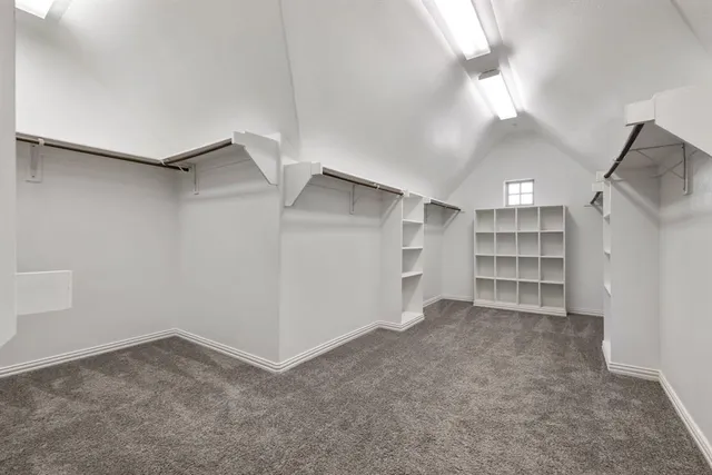 a view of an empty room with closet and racks