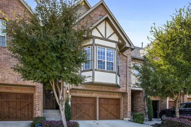 a front view of a house with a tree