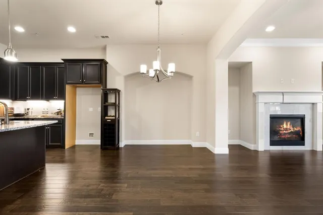a view of a kitchen with refrigerator and wooden floor