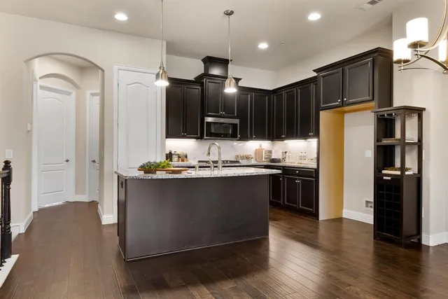 a kitchen with kitchen island granite countertop wooden cabinets and stainless steel appliances