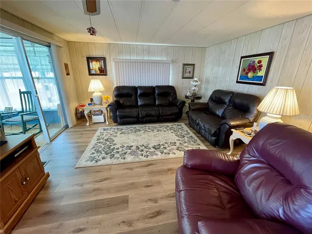 a living room with furniture ceiling window and a flat screen tv