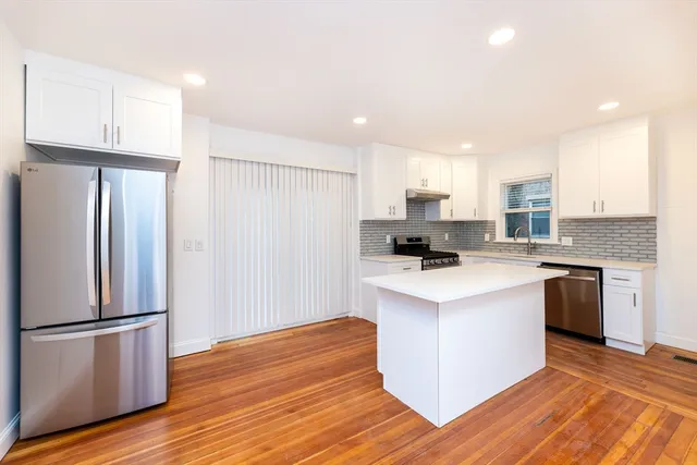 a kitchen with a refrigerator sink and cabinets