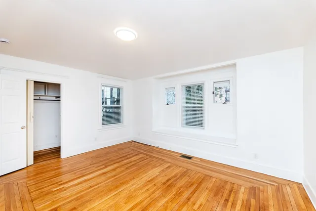 a view of a room with wooden floor and window