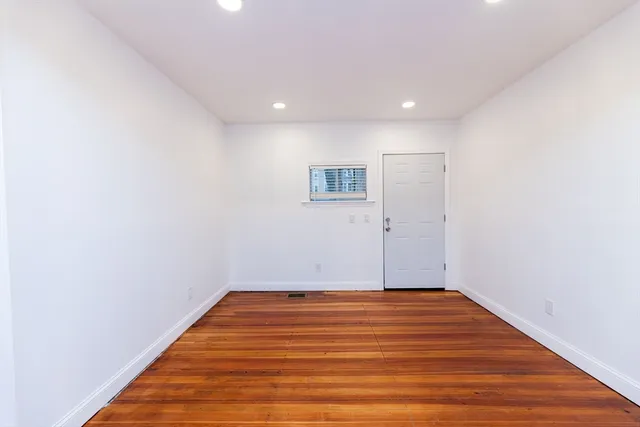 a view of a room with wooden floor and white walls