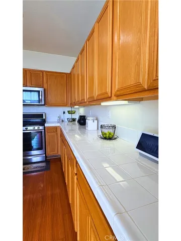 a kitchen with stainless steel appliances wooden cabinets a sink and a stove