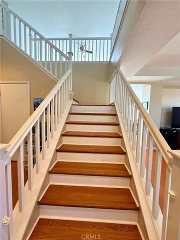 a view of staircase with lots of frames on wall and a window