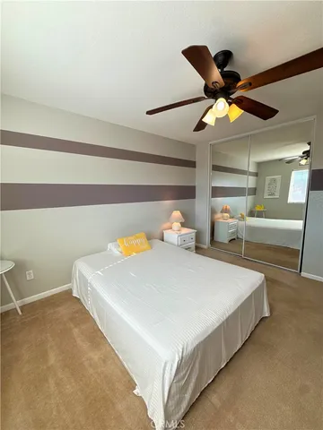 a bedroom with a bed and a ceiling fan