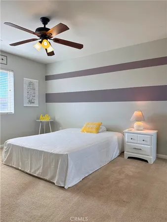 a bedroom with a bed and ceiling fan