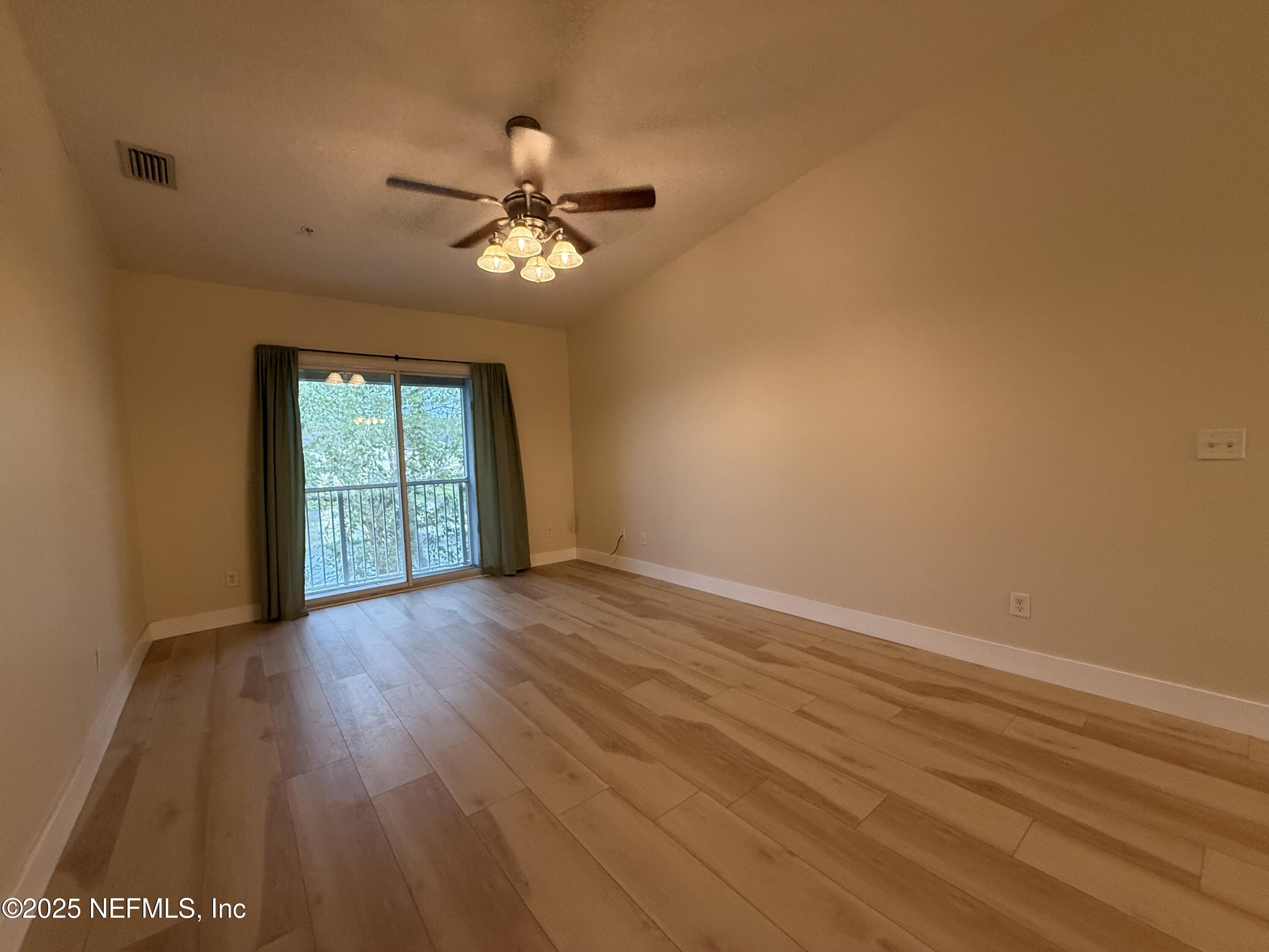 2564 Golden Lake Loop St. Augustine, FL 32084 - Photo 6 of 24 a view of an empty room with a window and wooden floor