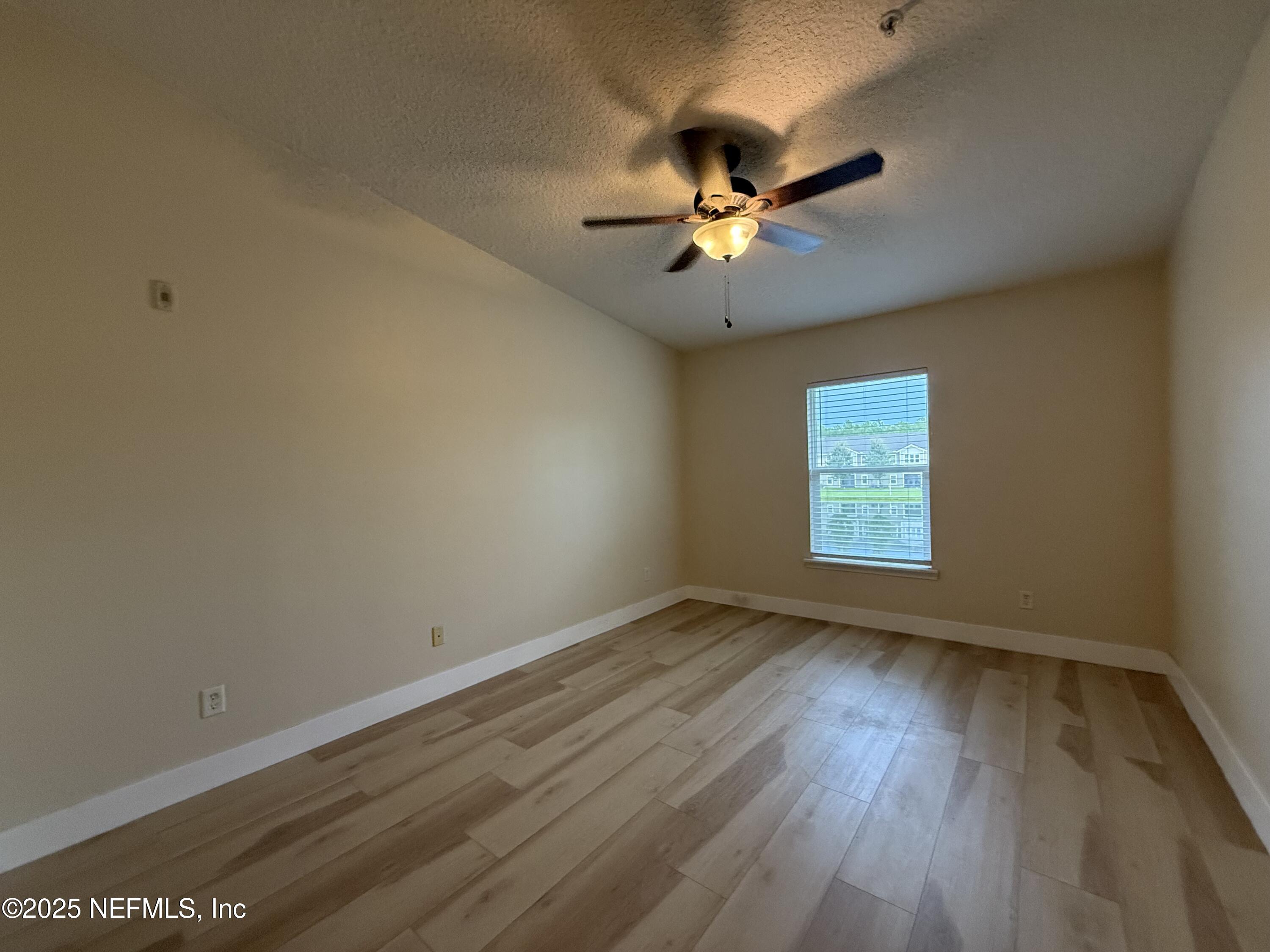 2564 Golden Lake Loop St. Augustine, FL 32084 - Photo 7 of 24 a view of an empty room with a window and wooden floor