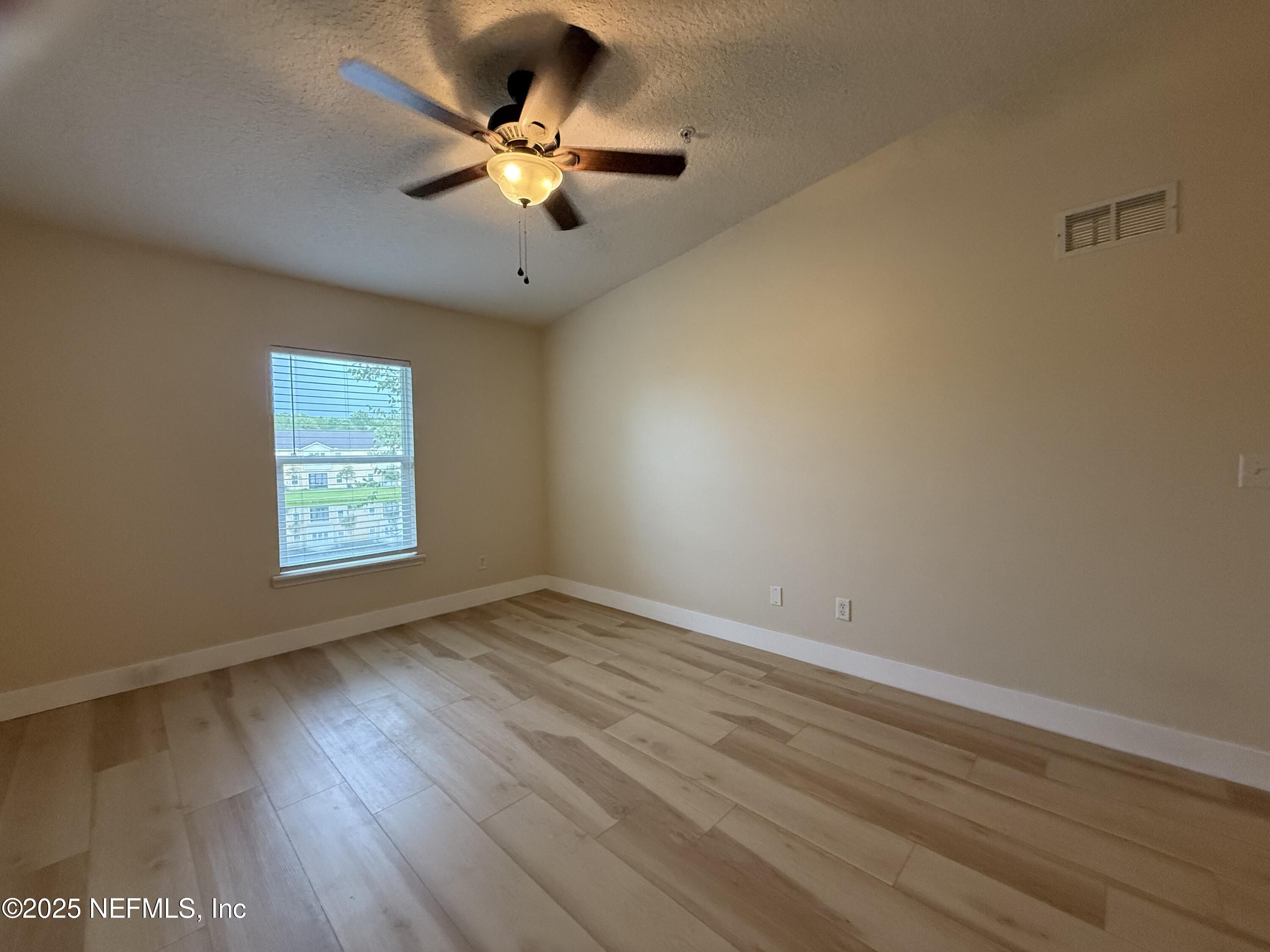 2564 Golden Lake Loop St. Augustine, FL 32084 - Photo 8 of 24 an empty room with wooden floor and windows