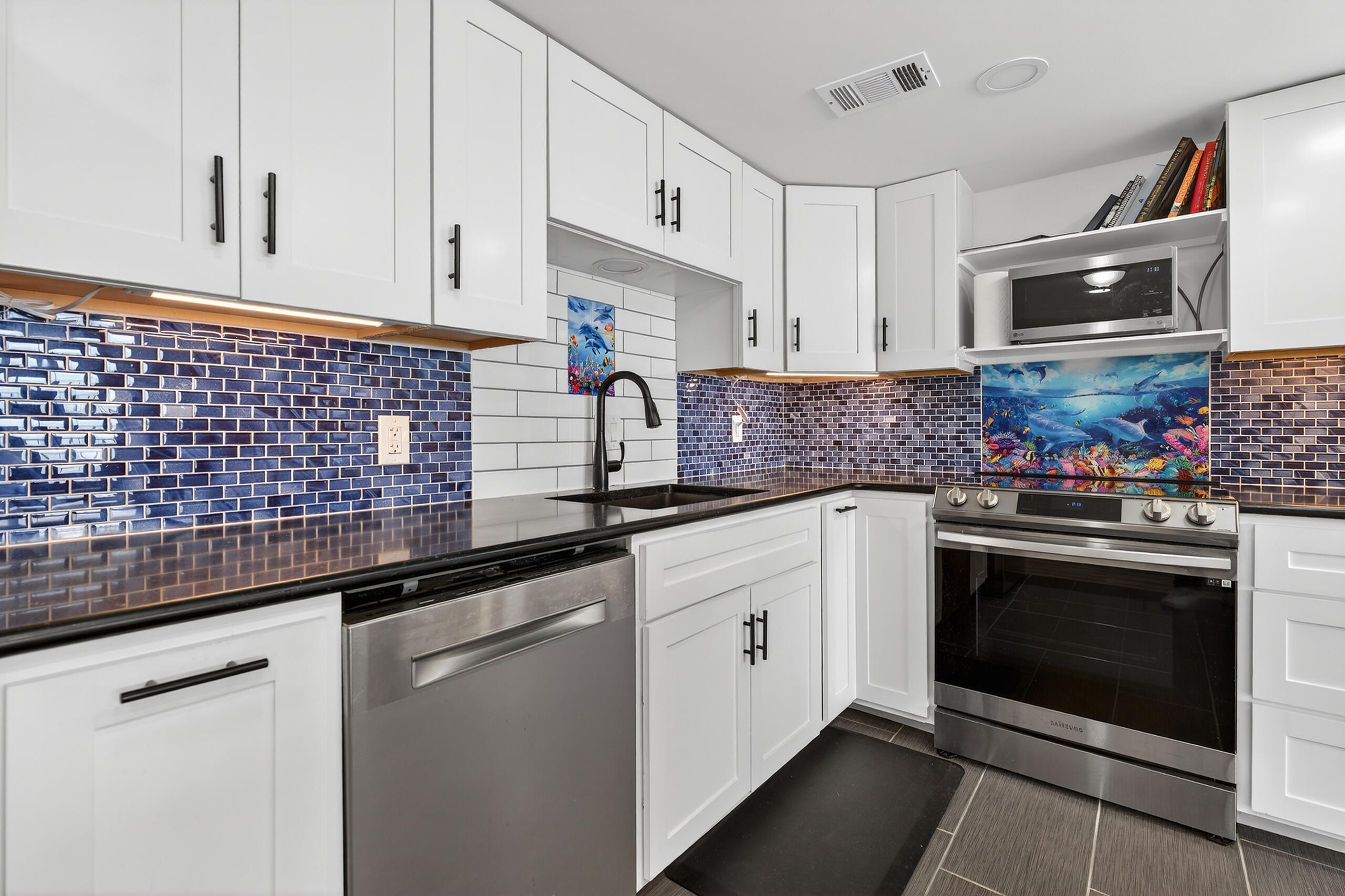 151 Calhoun Avenue, Unit 301 Destin, FL 32541 - Photo 13 of 43 a kitchen with stainless steel appliances granite countertop a stove a sink and a microwave