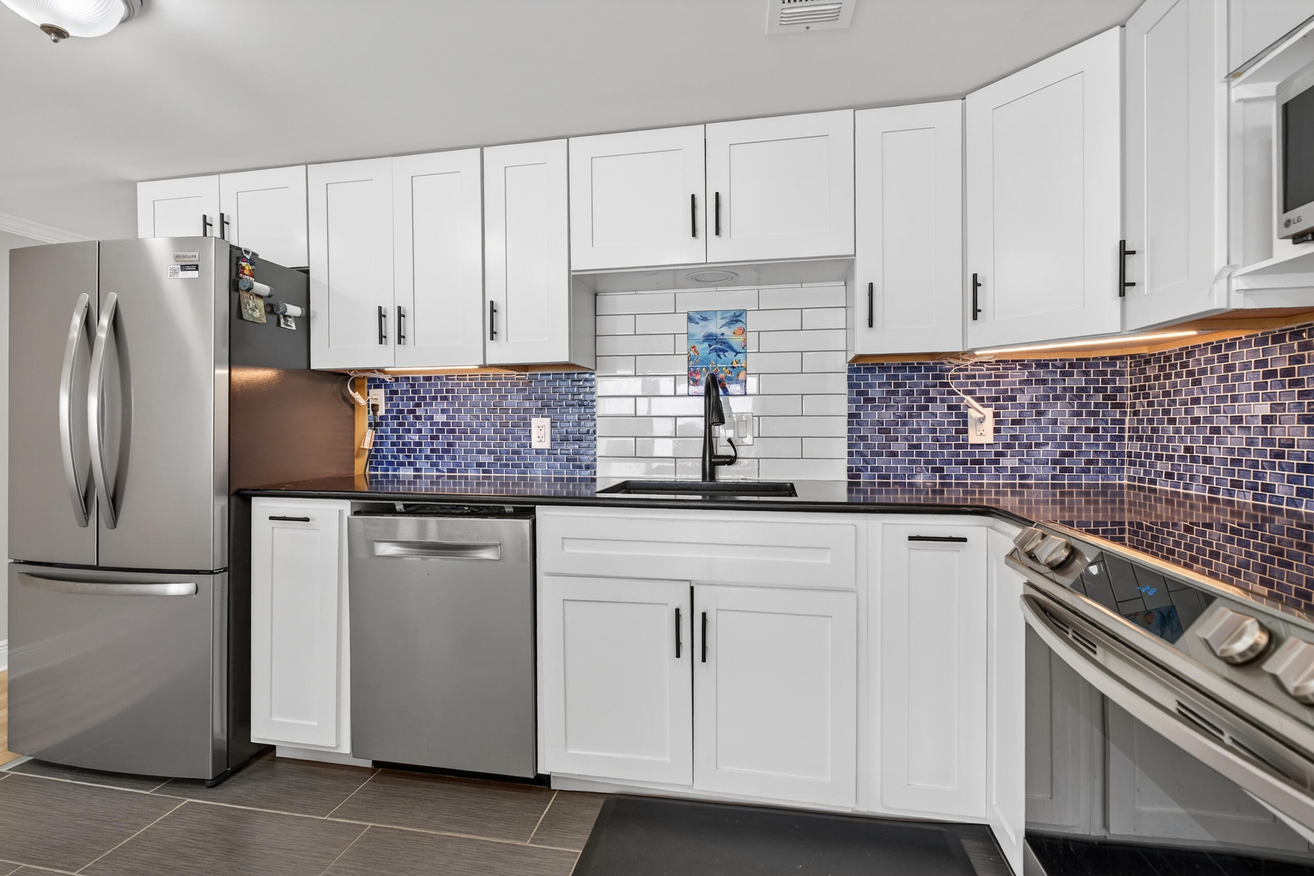 151 Calhoun Avenue, Unit 301 Destin, FL 32541 - Photo 14 of 43 a kitchen with white cabinets and white appliances