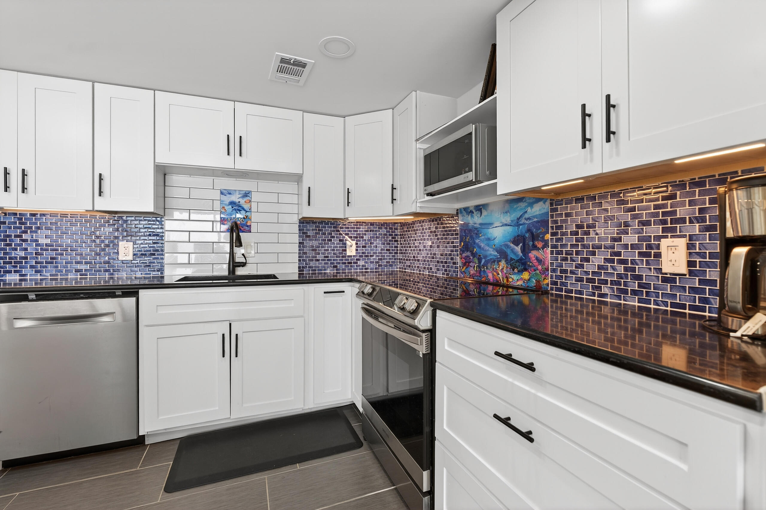151 Calhoun Avenue, Unit 301 Destin, FL 32541 - Photo 15 of 43 a kitchen with granite countertop white cabinets stainless steel appliances and a sink