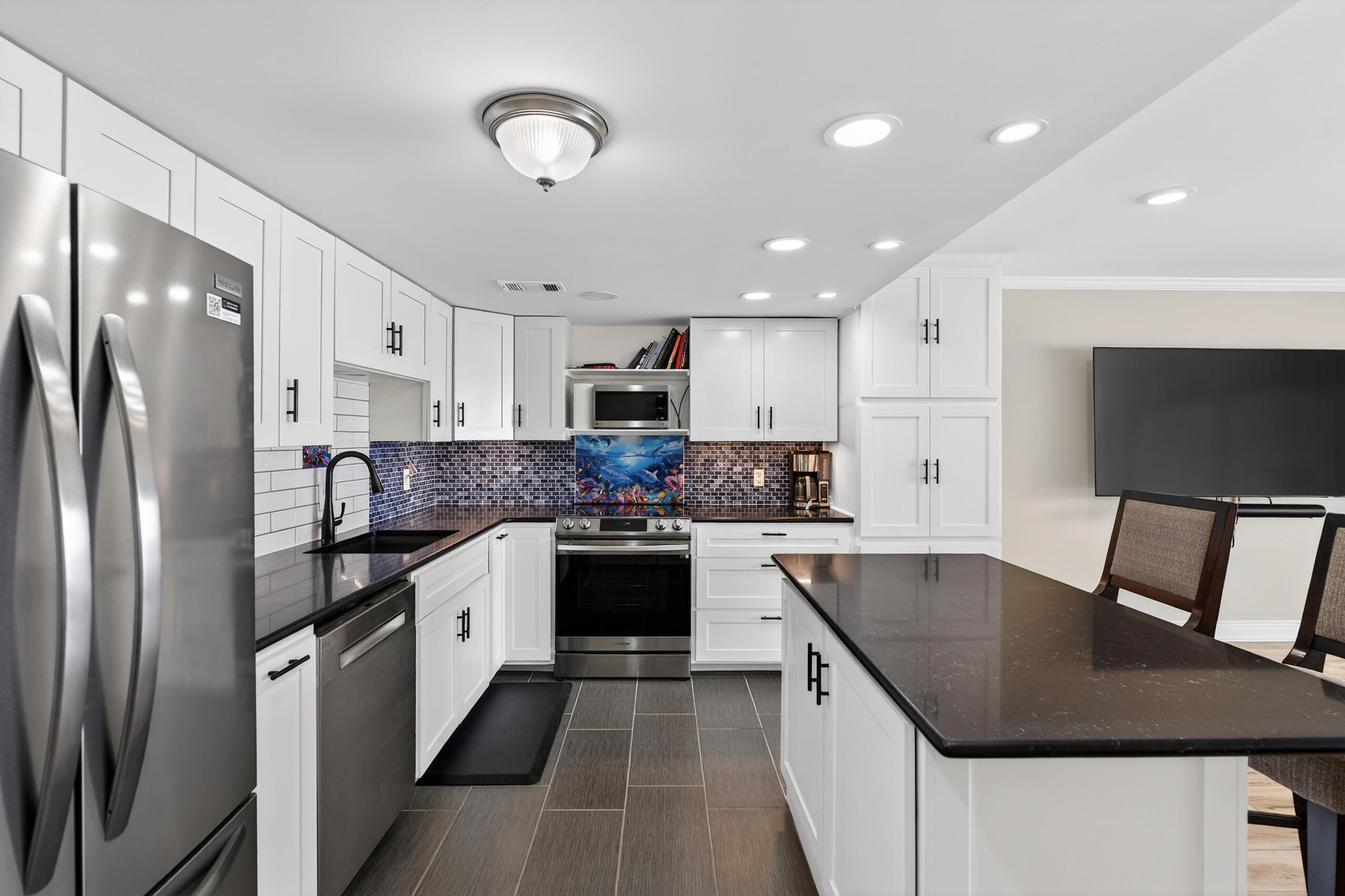 151 Calhoun Avenue, Unit 301 Destin, FL 32541 - Photo 16 of 43 a kitchen with stainless steel appliances granite countertop a sink refrigerator and microwave