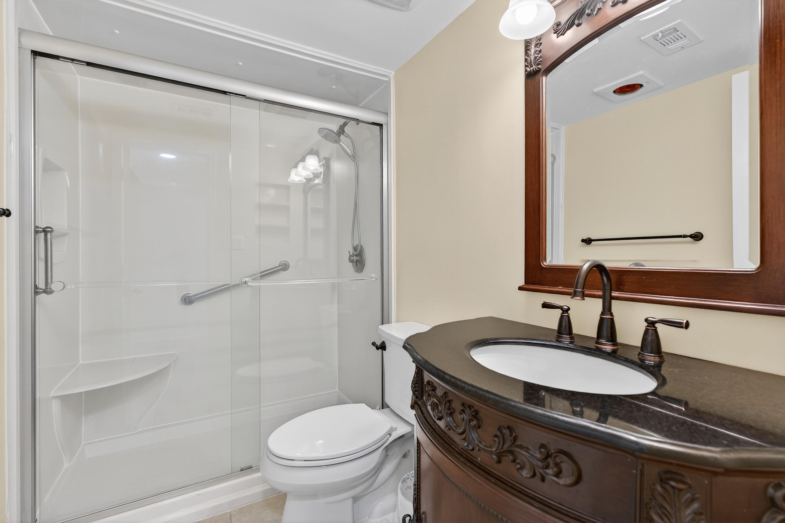 151 Calhoun Avenue, Unit 301 Destin, FL 32541 - Photo 21 of 43 a bathroom with a granite countertop sink toilet a mirror and shower