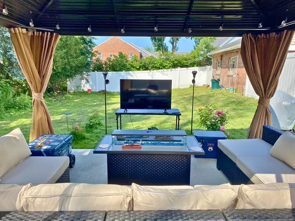a view of a patio with table and chairs potted plants with wooden floor and a garden view