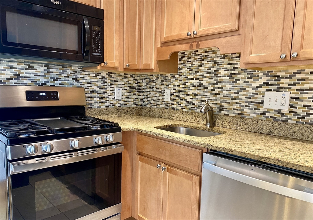 30 Maple Avenue, Unit 2 North Andover, MA 01845 - Photo 9 of 17 a kitchen with granite countertop stainless steel appliances a sink stove and microwave