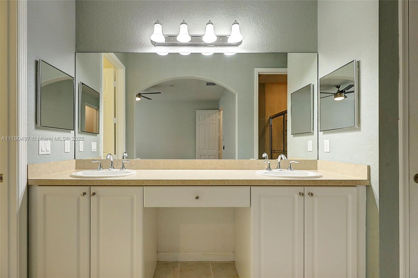 9469 Southwest Purple Martin Way Stuart, FL 34997 - Photo 15 of 21 a bathroom with a double vanity sink and a mirror