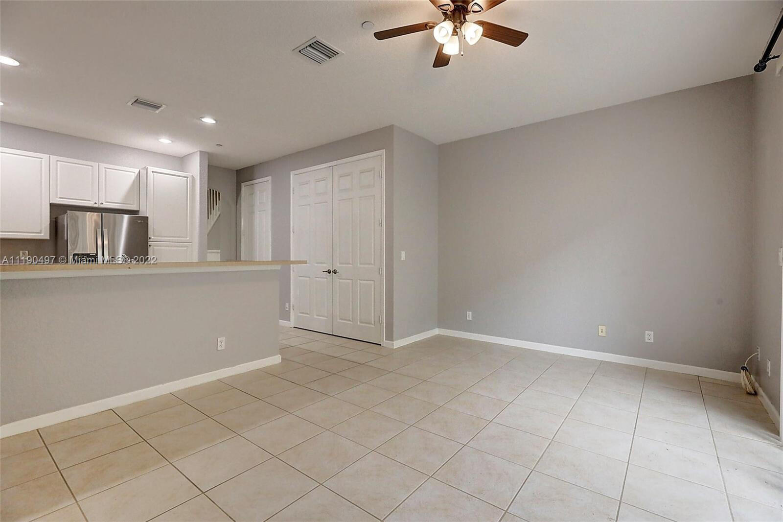 9469 Southwest Purple Martin Way Stuart, FL 34997 - Photo 16 of 21 an empty room with chandelier fan and windows