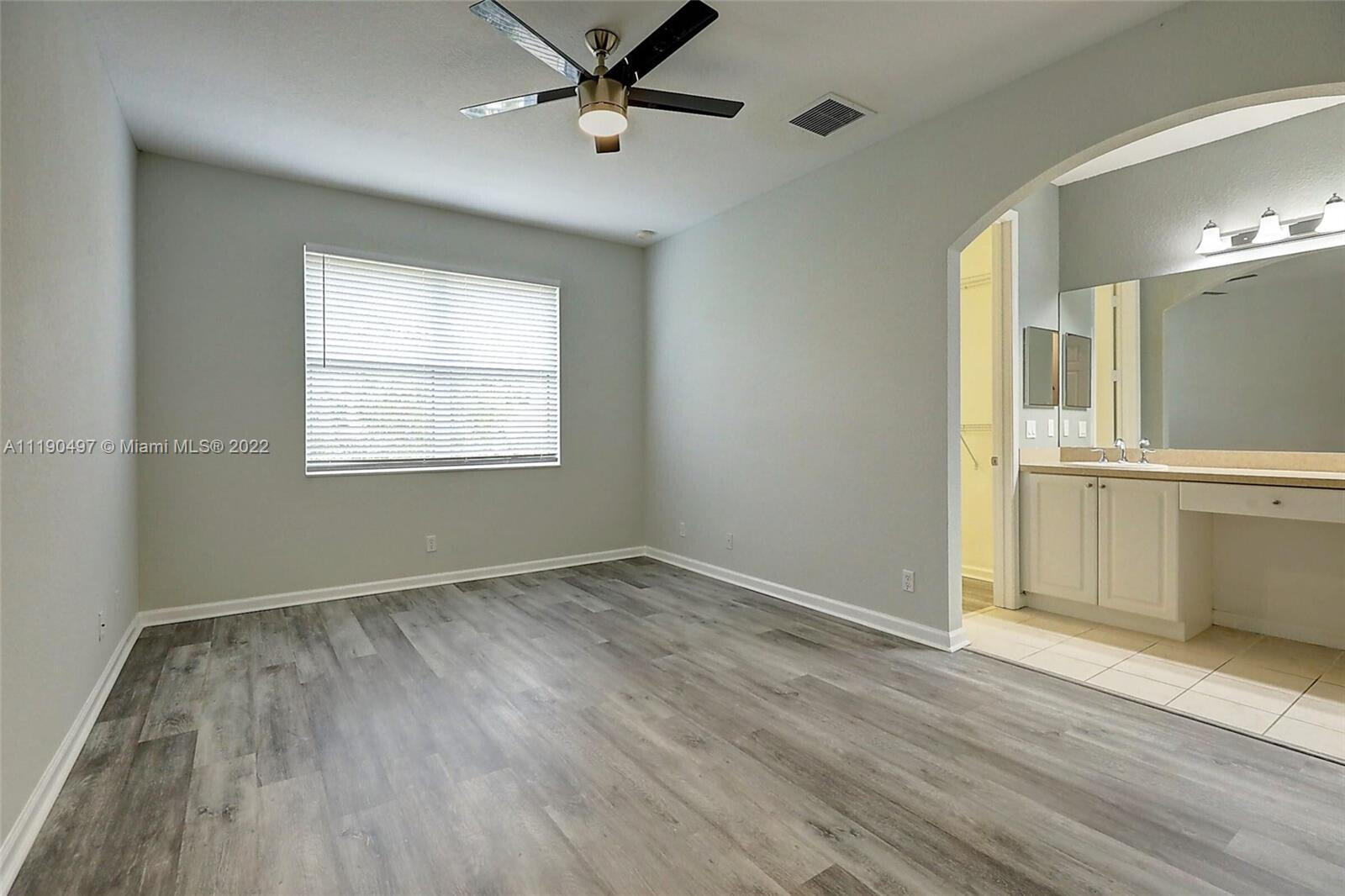 9469 Southwest Purple Martin Way Stuart, FL 34997 - Photo 9 of 21 a view of empty room with wooden floor and fan